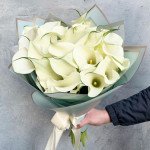 25 белых калл в голубой упаковке с лентами